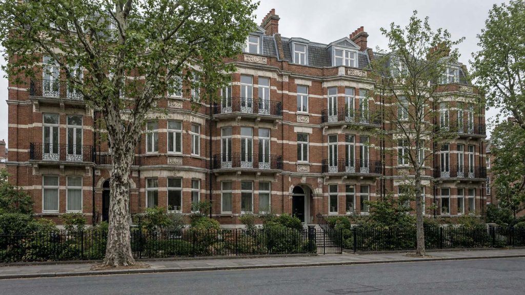 A red brick Edwardian mansion block of flats with iron balconies, typical of north London